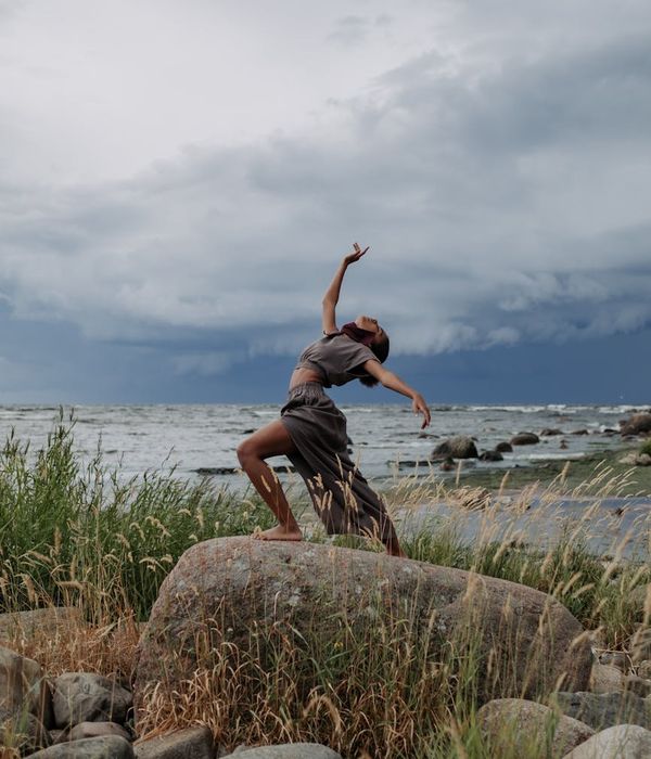 Person in a fluid motion pose against a minimal background.