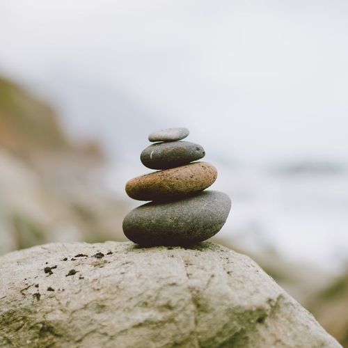 Stacked stones on a tranquil beach symbolizing balance.